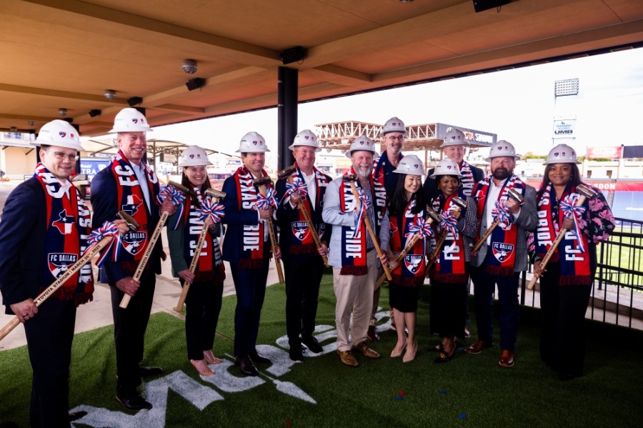 Representatives from the city of Frisco and FC Dallas wearing hard hats and holding shovels while they celebrated the start of renovations at Toyota Stadium.